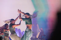 two dancers performing on stage in front of a colorful background
