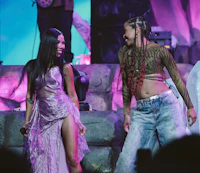 two women standing on stage at a concert